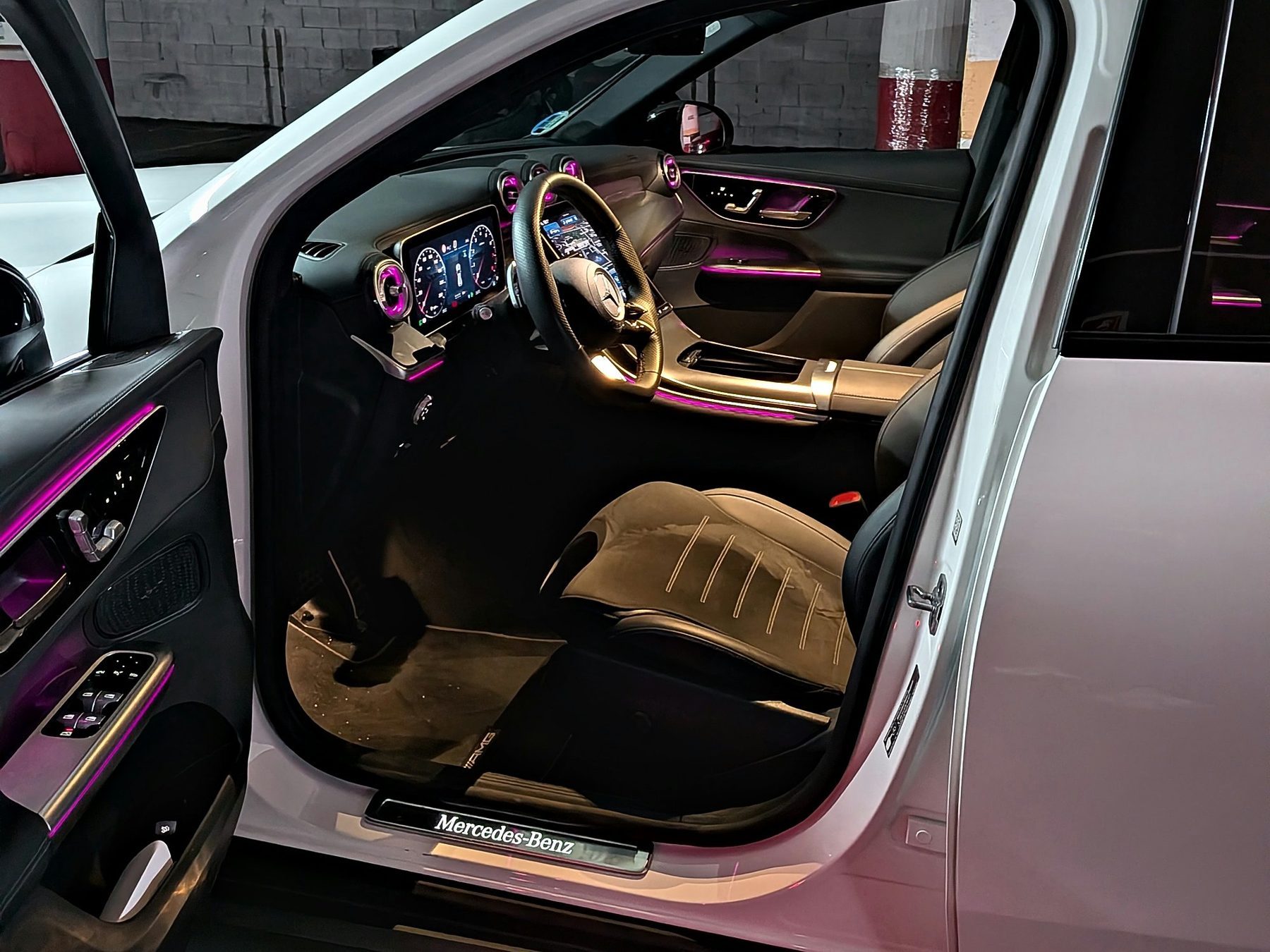 Interior del Mercedes GLC 200 4MATIC con la puerta abierta y la luz ambiente